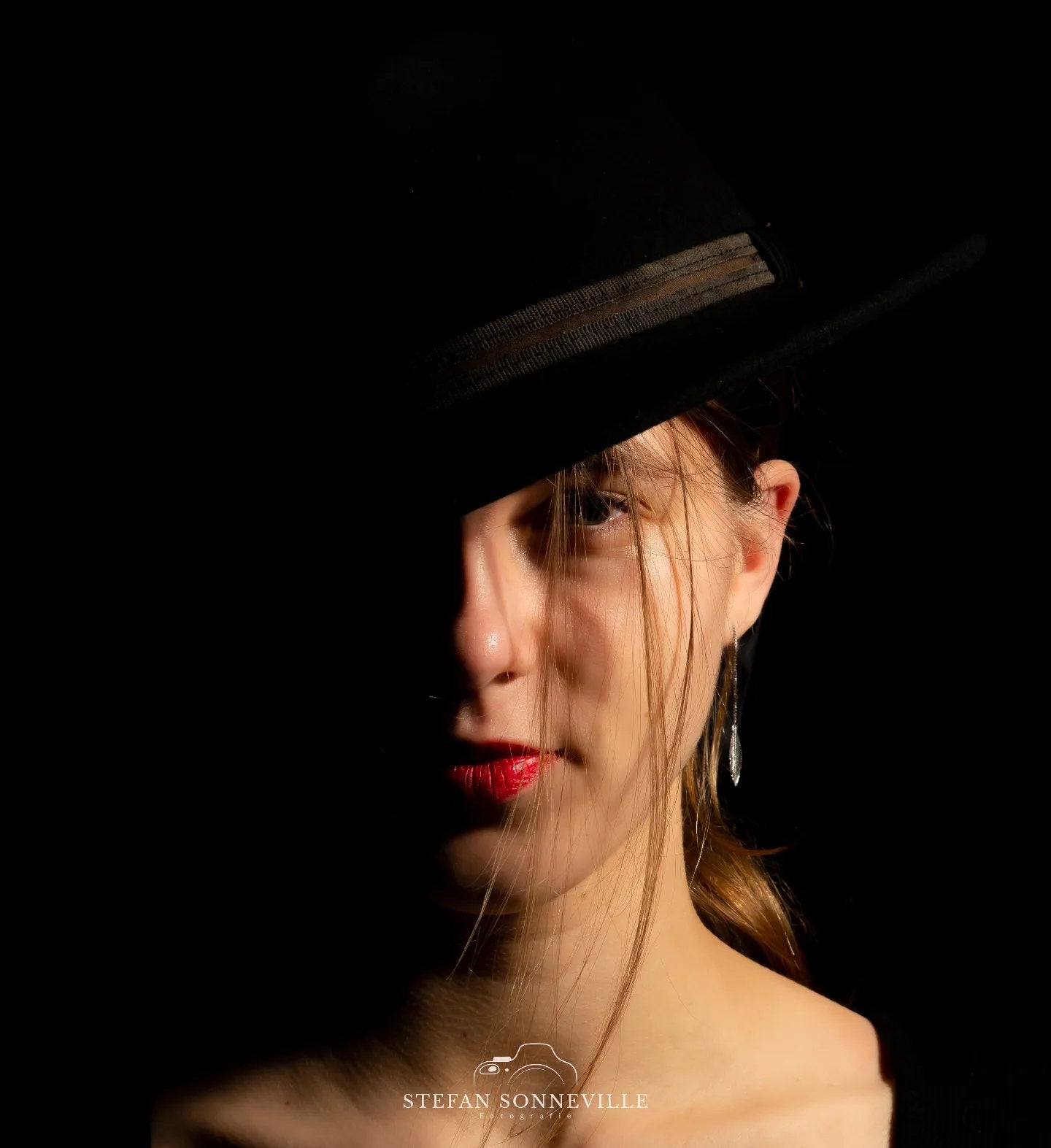 Model met hoed in fotografie studio met flitslicht