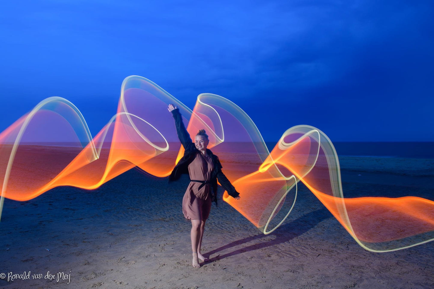 Model op strand met vlammend lichteffect  met light tube painting