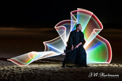 On the beach with light tube painting with light, fighter in action